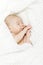 Sleeping newborn baby covered with white blanket