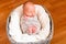 Sleeping newborn baby in the gray basket. Small hands and feet of the child. Baby wrap