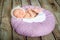 Sleeping newborn baby on a violet pillow