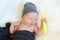 Sleeping newborn baby with yellow spoon in hand