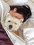 Sleeping with pets: woman cuddling west highland terrier westie