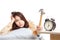 Sleepy Asian girl wake up hit alarm clock with hammer