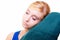 Sleepy blond girl with green pillow isolated over