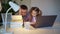 Sleepy dad helps daughter to do fun online lessons on laptop. distance learning