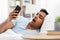 Sleepy indian man with smartphone lying in bed