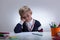 Sleepy little boy next to desk