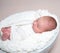 Sleepy newborn baby on white bowl