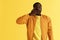 Sleepy tired black man yawning on yellow background portrait