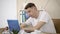 Sleepy young man yawning and putting head on the table. portrait of exhausted Caucasian guy sleeping in front of laptop