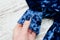 Sleeve of blue velvet dress in female hand. Fashionable concept