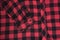 Sleeve of checkered black and red textured fabric. Close-up