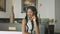 Slender African-American woman with dark hair in a stylish dress sits in a beautiful interior of the hotel room