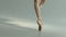 Slender balarina legs in pointe shoes perform pirouette movements. Fascinating dance. White background. Close up. Slow
