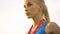 Slender blonde lady proudly looking forward, won medal in sports competition