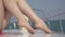 Slender female feet on a yacht floating on the sea