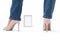 Slender female legs. Elegant patent beige high heels and blue jeans. The girl stands with her legs wide apart. Front