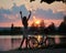 Slender female stands with her back, arms raised up against the backdrop of magical sunset near vintage bicycle