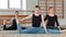Slender fit women doing yoga on exercise mats in fitness hall