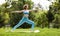 Slender focused girl performing yoga outside in early morning in park, standing in warrior pose