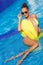 A slender girl with yellow pareo by the pool