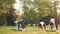 Slender girls in sportswear are doing yoga together in group at outdoor class in park developing strength and