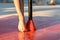 Slender nude female legs and slim feet in pole dance class outdoors at sunset