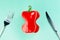 Slender red paprika with Cutlery on a turquoise background. Flat lay. Copy space. The concept of diet, weight loss and healthy