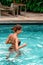 Slender tanned woman swimming at the pool. Rest and spa. Close up