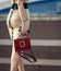 A slender woman in a dress with a handbag climbs elegantly up the stairs, rear view