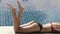 Slender woman legs sunbathes near pool