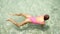 A slender woman in a pink bodysuit enjoys a seaside vacation. Real lifestyle handheld shots
