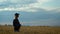 A slender woman walks on a wheat field and smiles on a Sunny summer day.