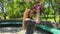 A slender young girl inhales the aroma of spring lilac flowers in the park.