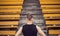 A slender young man in black sportswear stands in front of the stairs stadium stands. ready for action, step to victory, challenge