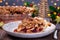 Slice of American apple cranberry pie, topped with crumbled dough and pecan, bokeh on background