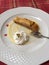 Slice of apple tart and cream on a white plate
