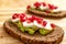 Slice of bread with avocado, cherry tomato, pomegranate seeds and fresh cheese