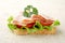 Slice of bread with lettuce,cold cuts on linen tablecloth