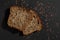 Slice of brown healthy multi grain bread close up  on black background