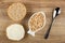 Slice of bun, sandwich with butter, canned cod caviar in bowl in fish shape, spoon on wooden table. Top view