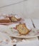 Slice of cake Ciambellone with crumbs on ceramic plate painted with floral motifs, cloth towel and mother of pearl fragments.