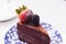 Slice of chocolate cheesecake topping with fresh strawberry and blackberry