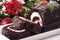 Slice of Christmas yule log cake on plate with decoration