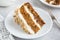 Slice of delicious carrot cake with cream cheese frosting and nu