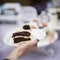 Slice of delicious chocolate cake with cream and blackberries, plate in hand, fresh summer dessert, selective focus