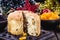 Slice of delicious panettone with candied fruits with blinking blurred Christmas lights, bread with fruits