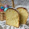 Slice of easter orthodox sweet bread, kulich on wooden background with floral fabric. Retro style. Breakfast. Close up