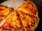 Slice of frehly cooked cheese and tomato pizza on a wooden chopping board