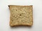 A slice of fresh bran bread lying close up on a white background. Minimalism.