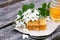 slice of fresh honey sat and bowl with yellow honeycomb with acacia flowers